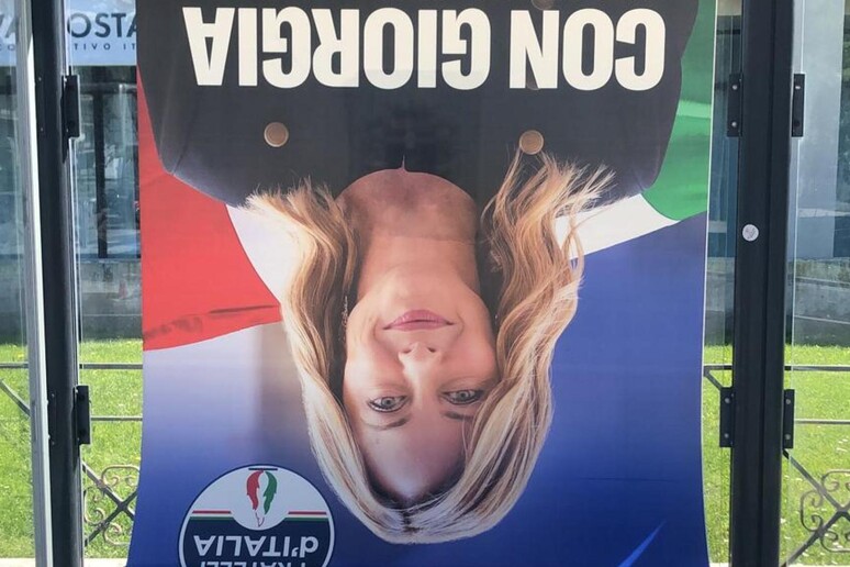 Aosta | Manifesto elettorale di Giorgia Meloni a testa in giù